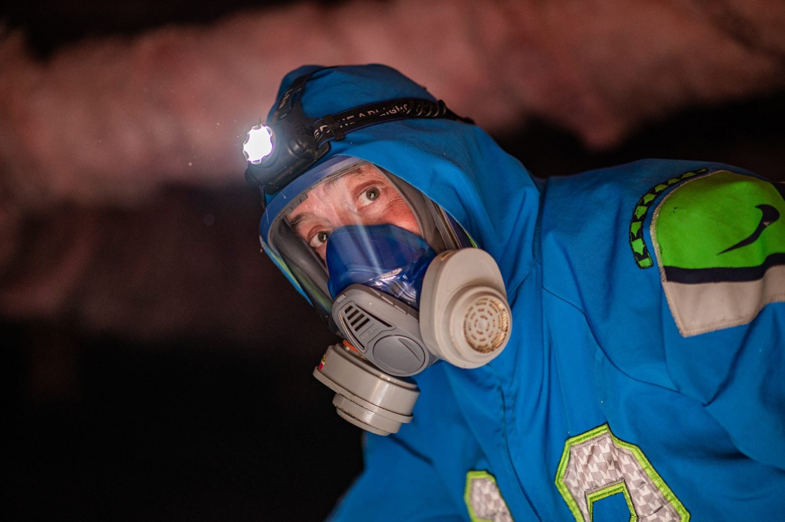 Bryan Mize in attic with headlamp
