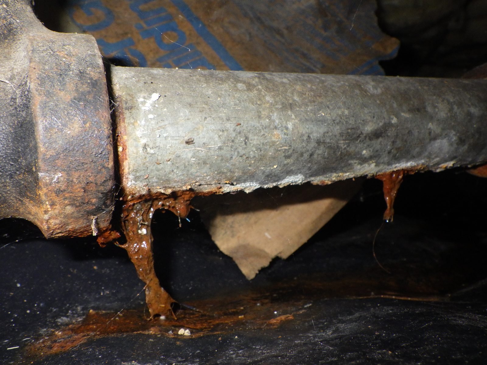 Failed galvanized waste pipe — active leak